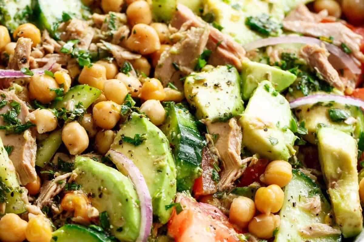 Add the tuna, chickpeas, avocado, tomato, cucumber, and red onion to a large bowl. Pour over the dressing, toss gently to coat