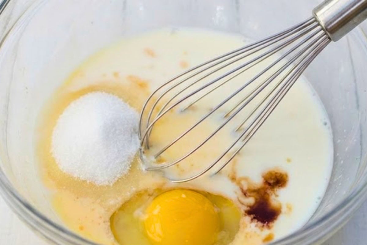 In a bowl, whisk together the egg, milk, sweetener or sugar, and vanilla