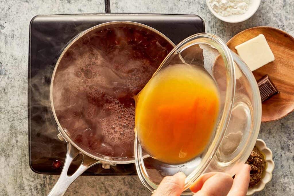 pouring the sauce into the pot
