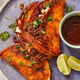 Crispy beef birria tacos with melty cheese and a rich red chile broth for dipping, bold, cheesy, and full of flavor.
