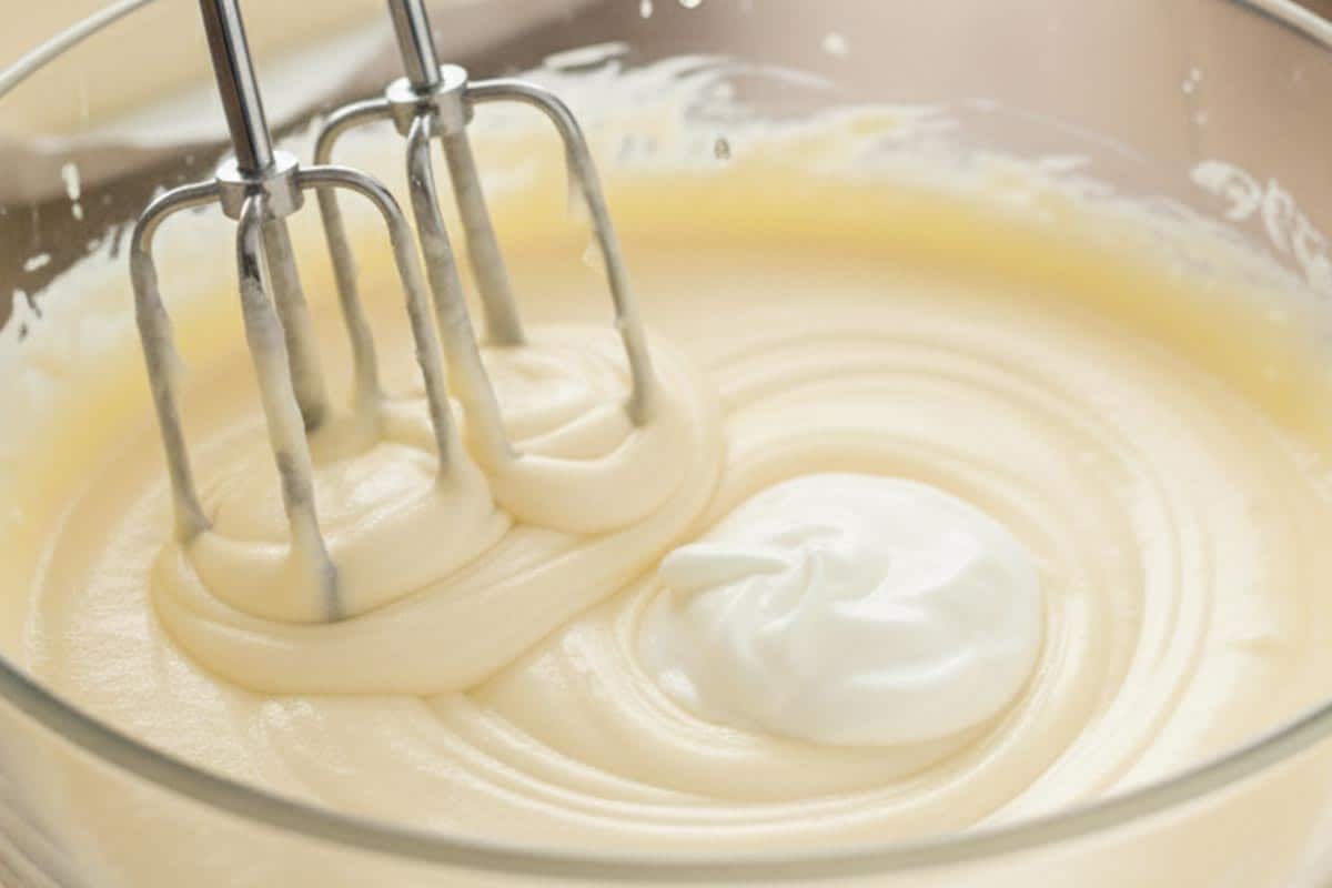 Beating cream cheese, Greek yogurt, powdered sweetener, flour, egg, and lemon juice.