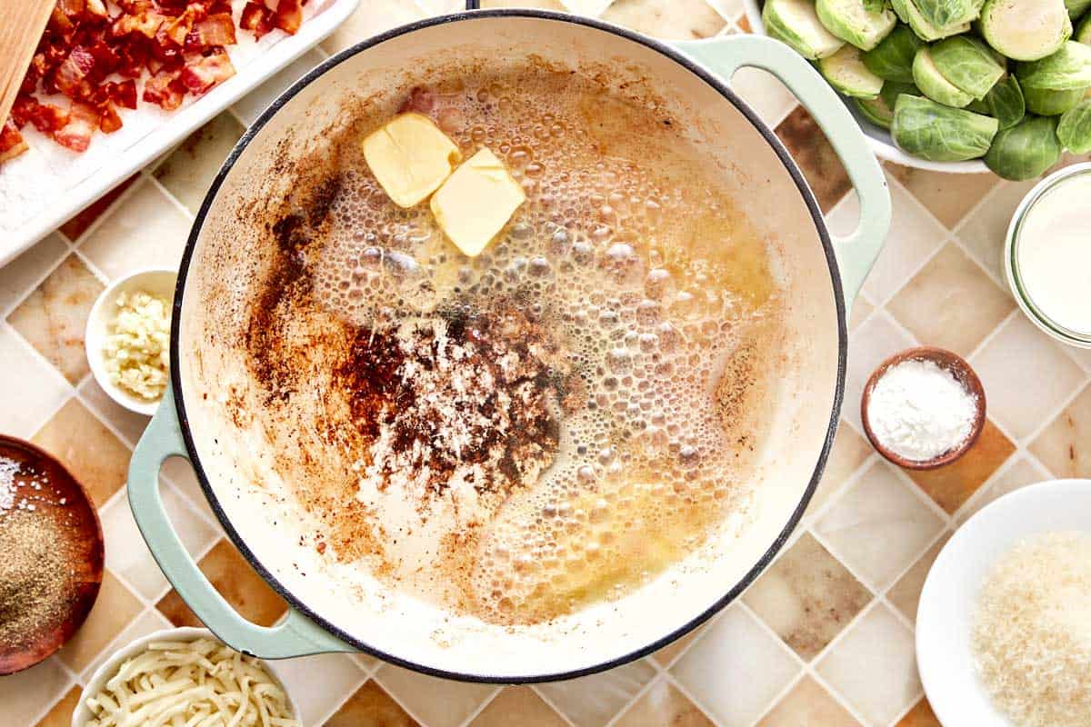 Butter melting in bacon drippings in a skillet