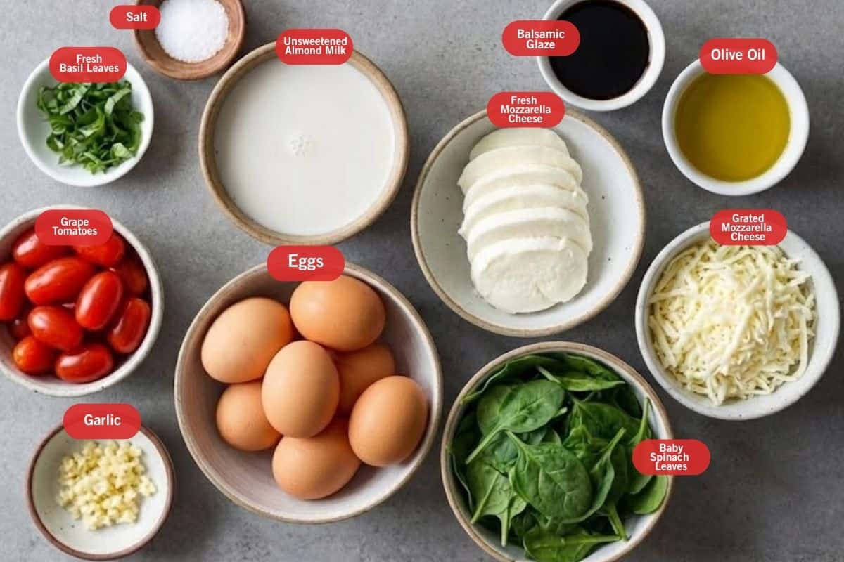 flat lay photo go ingredient shot of fresh basil leaves, salt, unsweetened almond milk, balsamic glaze, olive oil, grated mozzarella cheese, fresh mozzarella cheese, baby spinach leaves, eggs, garlic