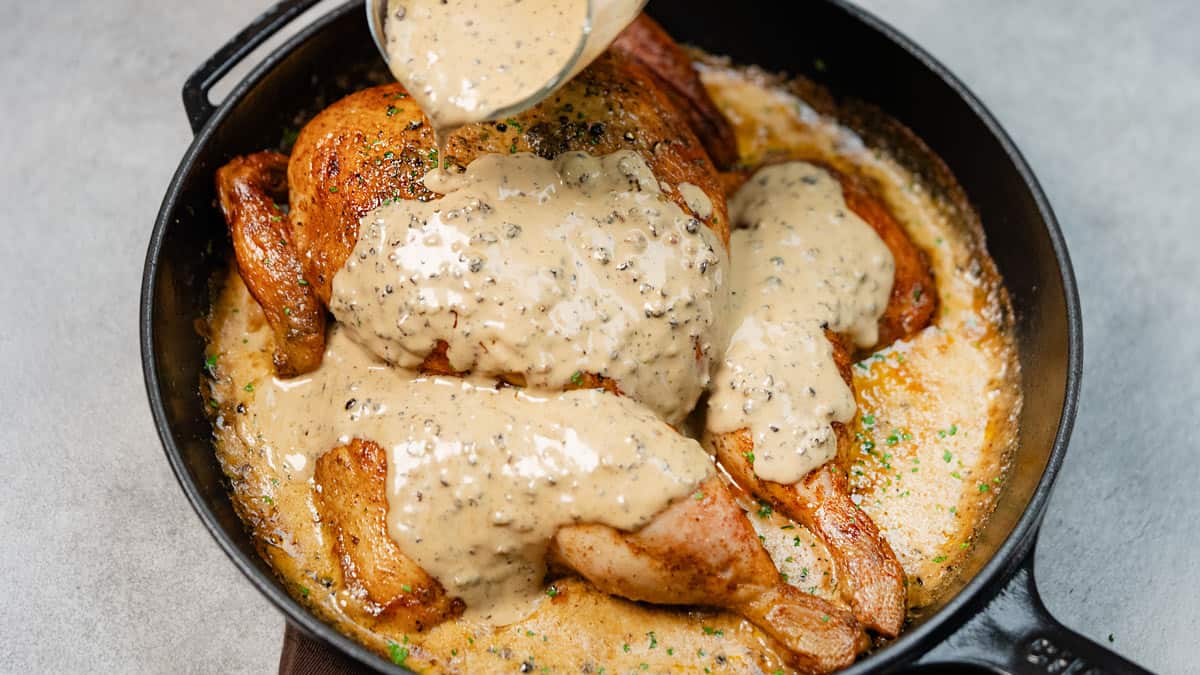 Pouring the sauce over the chicken, covering the whole dish