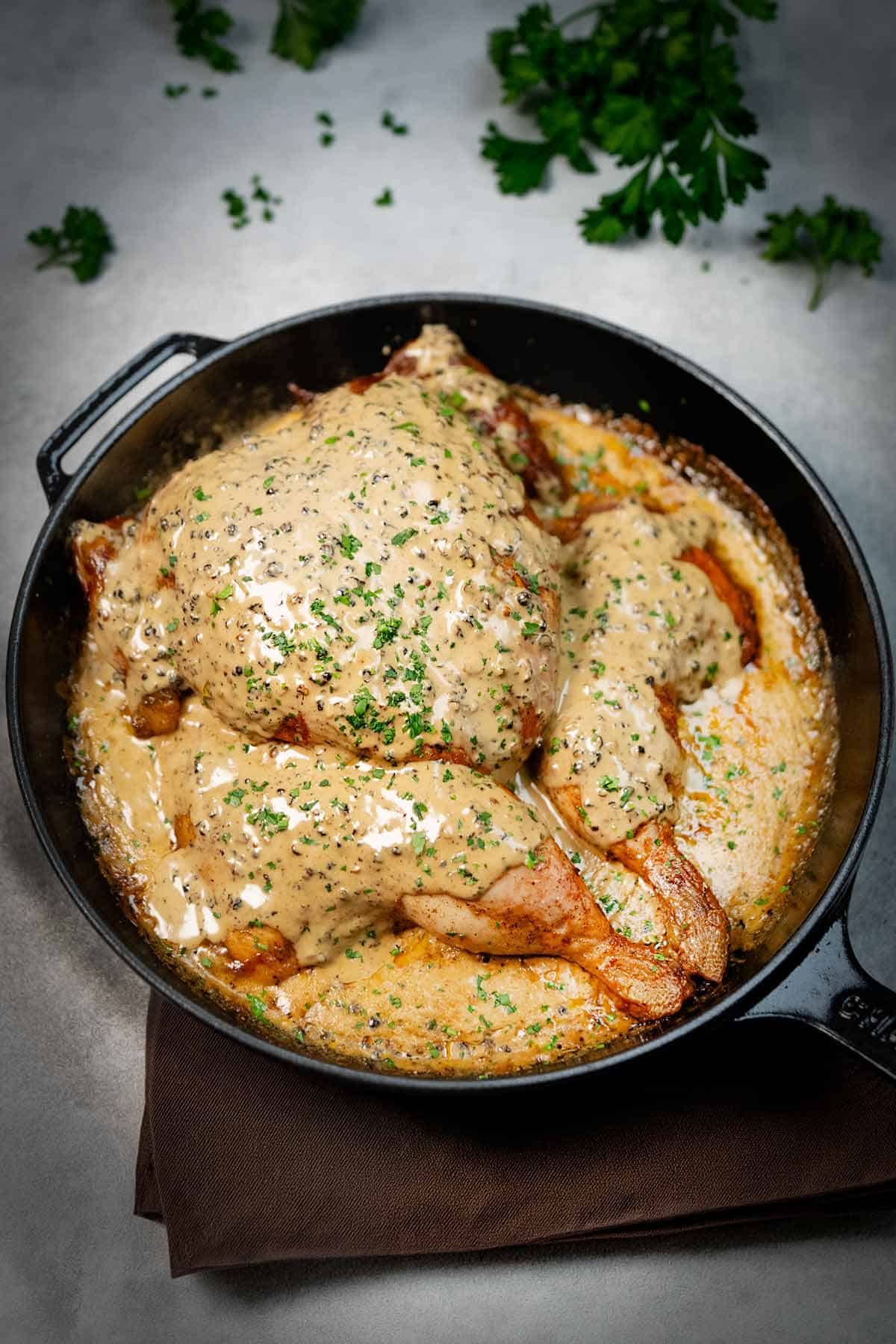 Chicken Au Poivre in a pan covered with creamy sauce