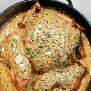 Chicken Au Poivre in a pan covered with creamy sauce