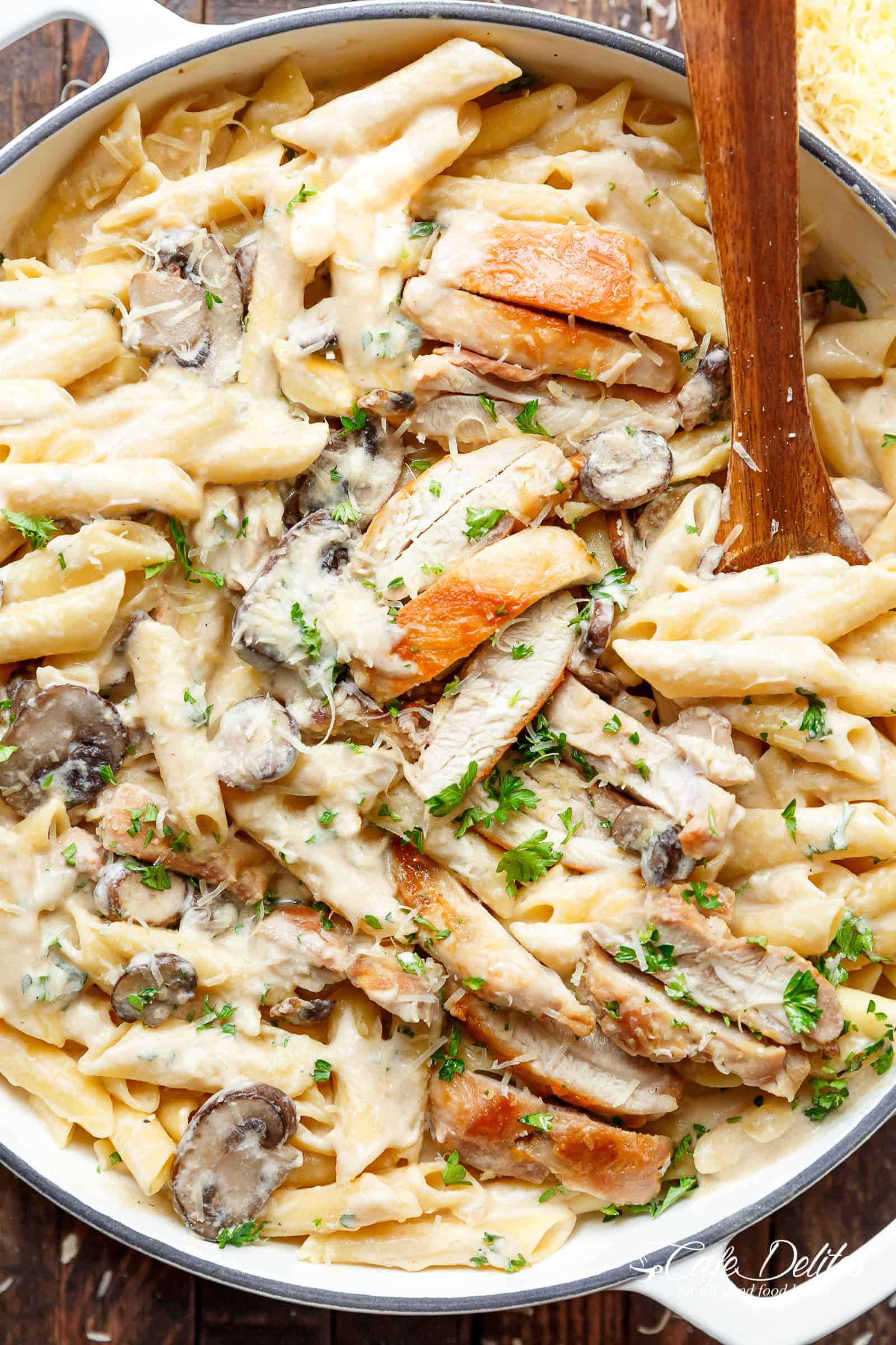 Creamy Garlic Parmesan Chicken Alfredo is all cooked in ONE POT! Ready and on the table in less than 20 minutes! Seared chicken is mixed through a super creamy garlic parmesan flavoured pasta with white wine and mushrooms! A favourite Chicken Alfredo recipe!