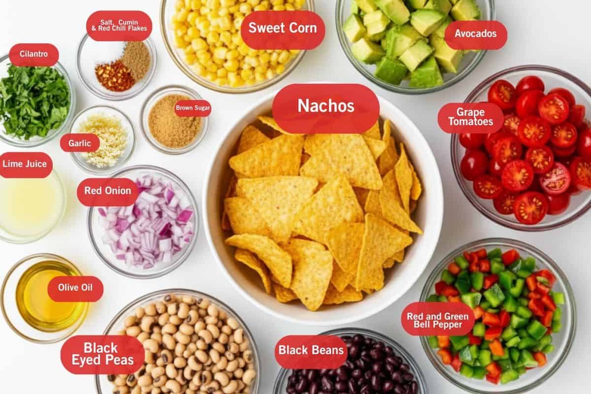 Flat lay photo of ingredient shot of cilantro, salt, cumin, red chili flakes, sweet corn, avocados, grape tomatoes, red and green bell pepper, black beans, black eyed peas, nachos, brown sugar, red onion, olive oil, lime juice, garlic, clinatro