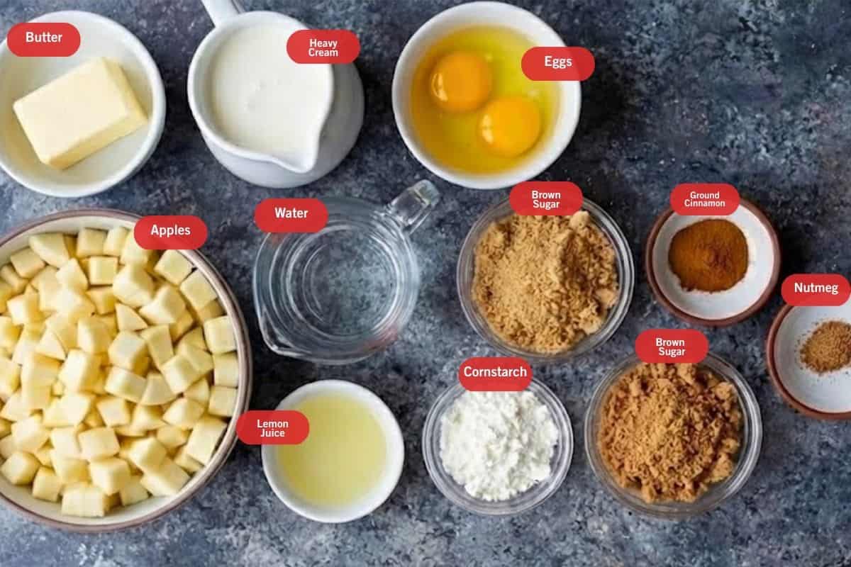 Flat lay photo of ingredient shot of butter, heavy cream,eggs, apples, lemon juice, brown sugar, cornstarch, ground cinnamon, nutmeg, water