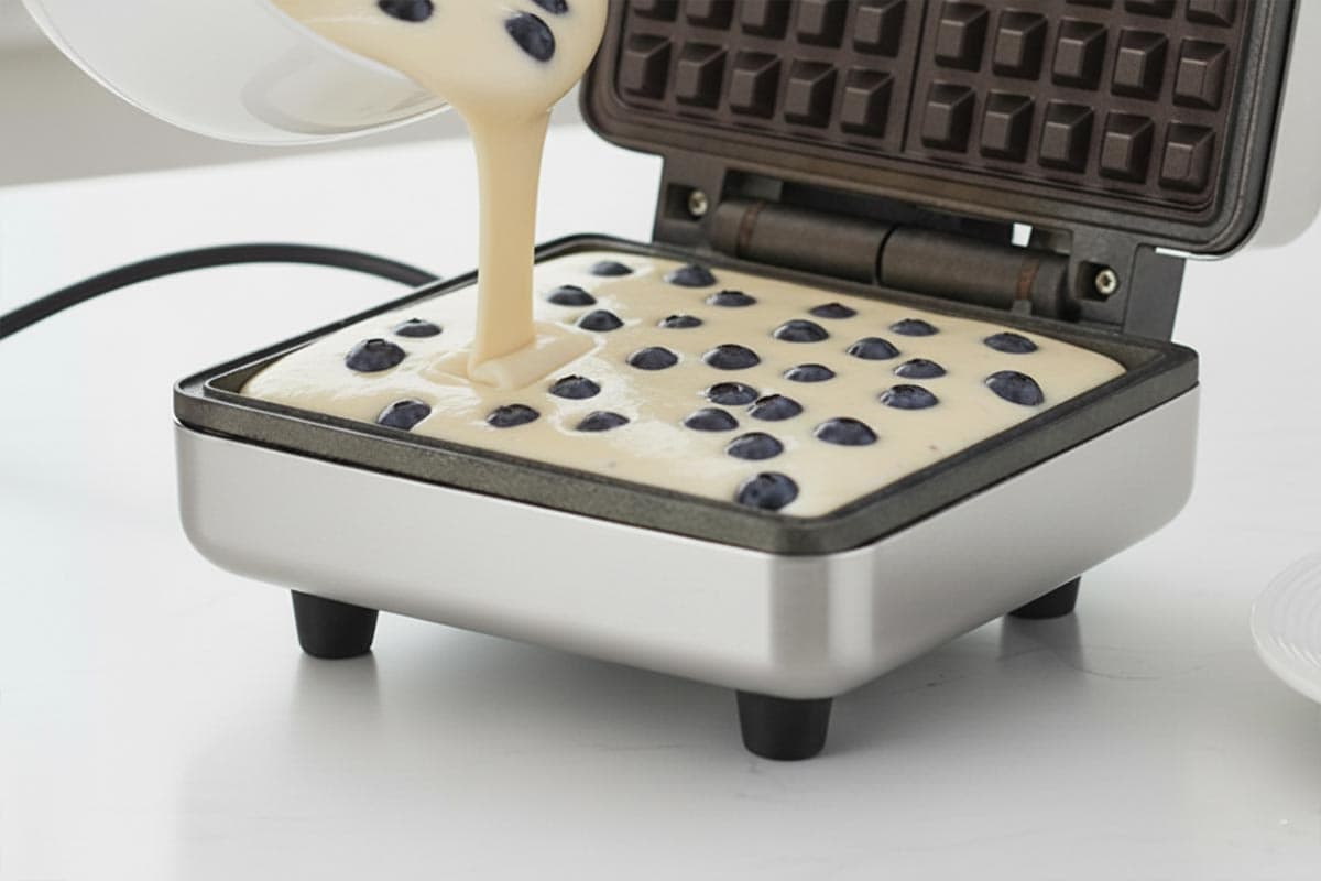 Pouring the batter into the waffle maker.