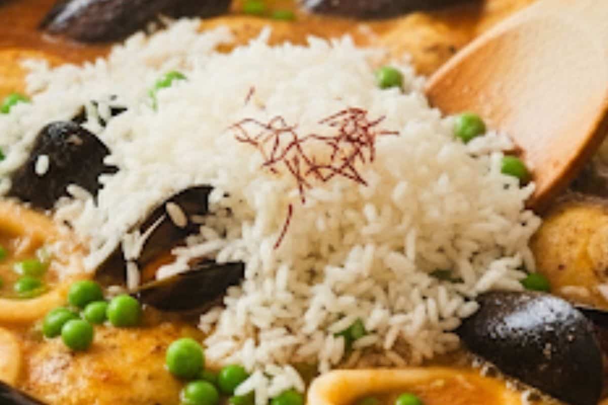 Pour in the chicken or fish stock, then add the rice, peas, and saffron and Stir well to combine.