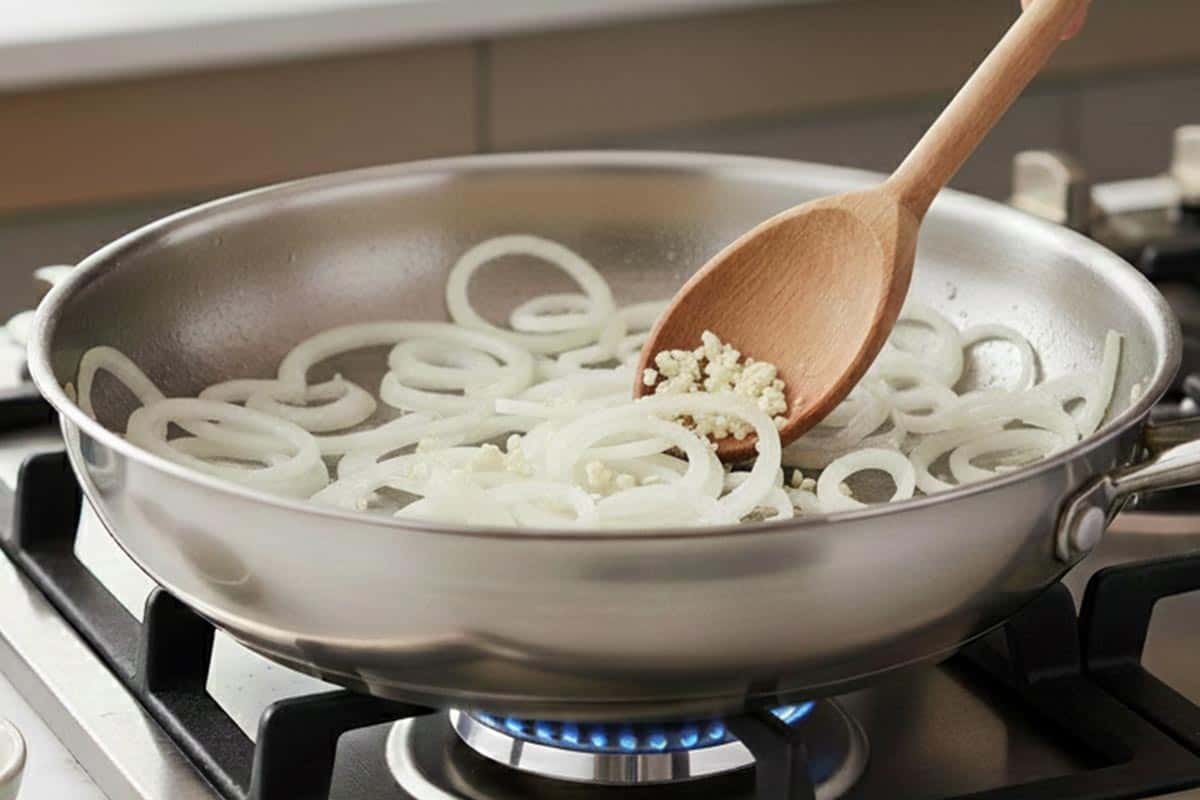 Sautéing onion and garlic in a pan.