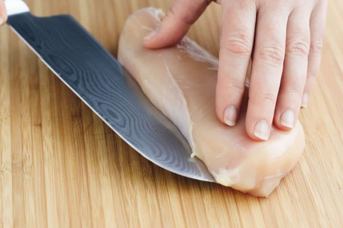 Slicing the chicken breast in half horizontally.