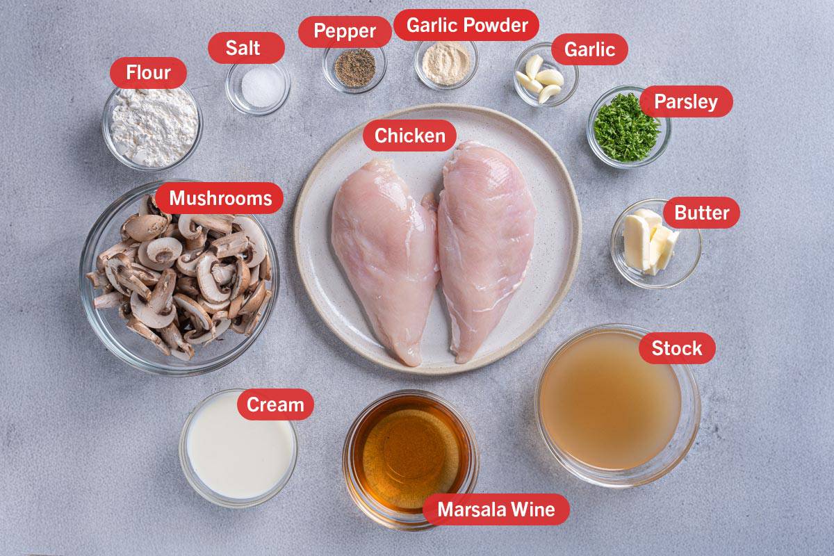 Image of the ingredients used for this recipe, specifically: chicken, mushrooms, flour, salt, pepper, garlic powder, garlic, parsley, butter, stock, marsala wine, and cream.