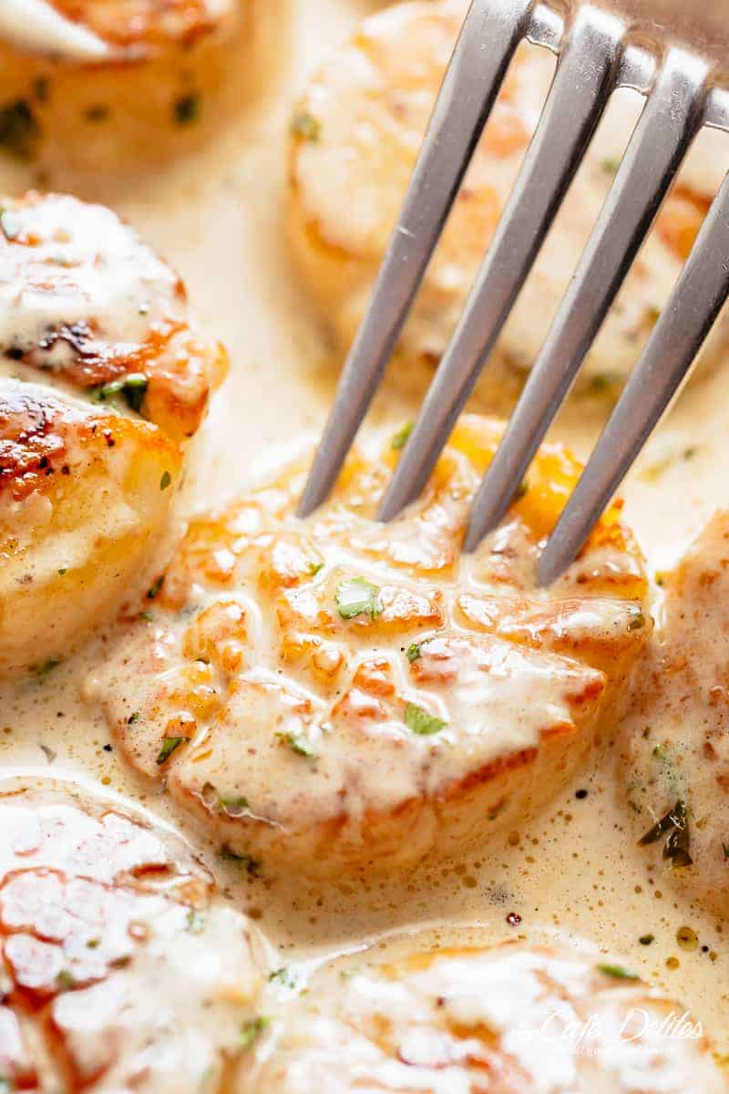 A fork pierced into a piece of Creamy Garlic Scallops