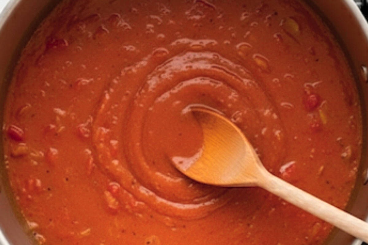 Pour in the chicken stock, passata, and tomato paste. Stir everything together.