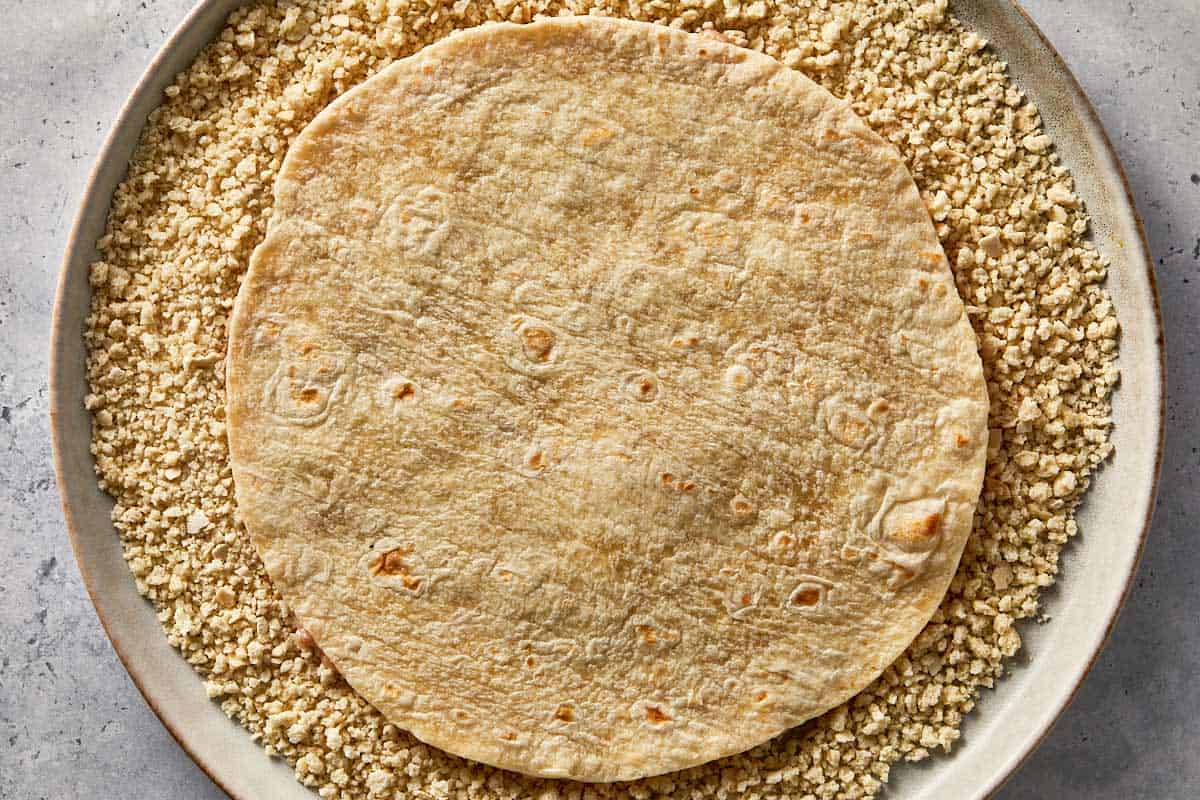 Tortilla pressed into panko breadcrumbs to coat the chicken layer