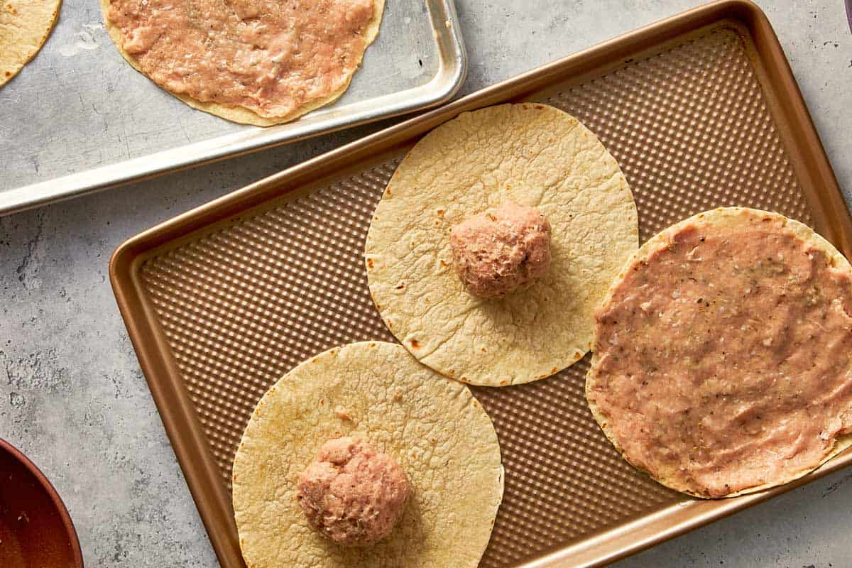 Ground chicken portion placed on small tortilla ready to be spread