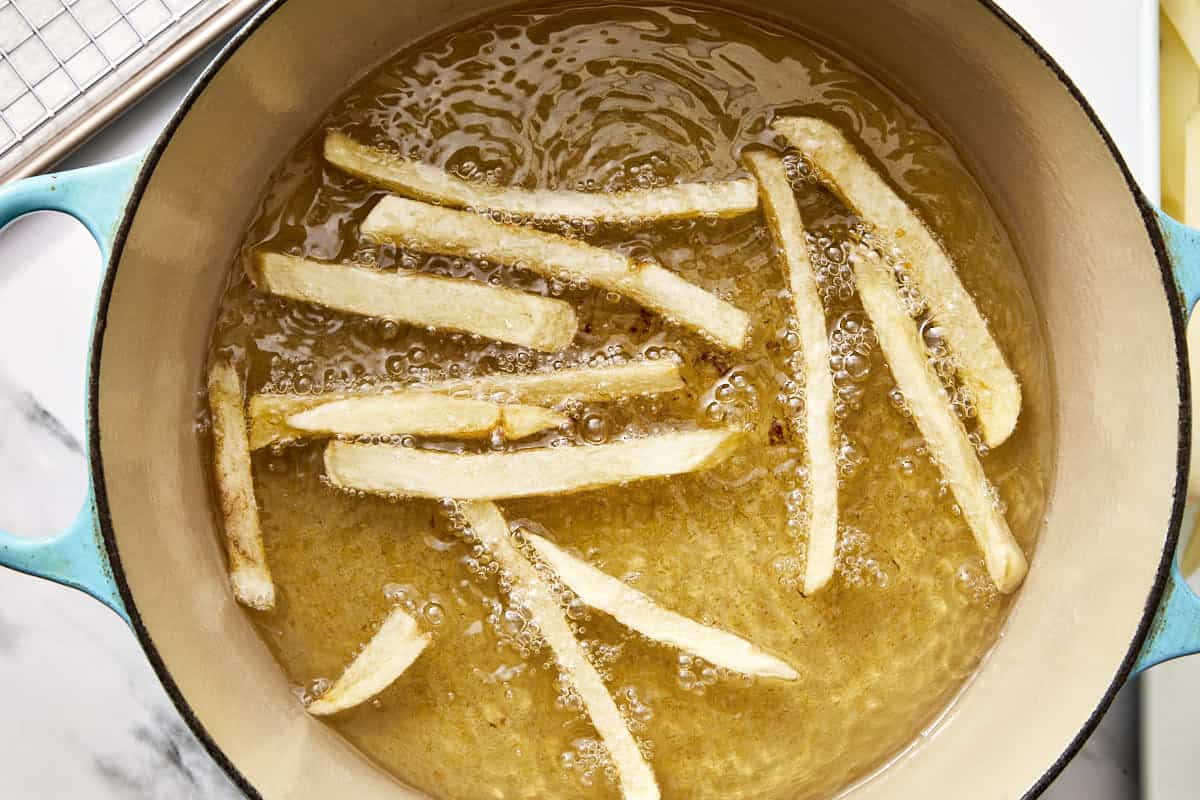 fries being cooked in a pot with oil