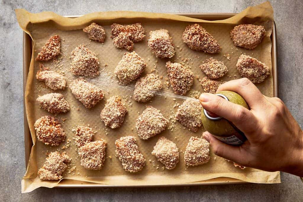 a top down view of a tray filled with chicken nuggets crumbed ready to be cooked in the oven, raw