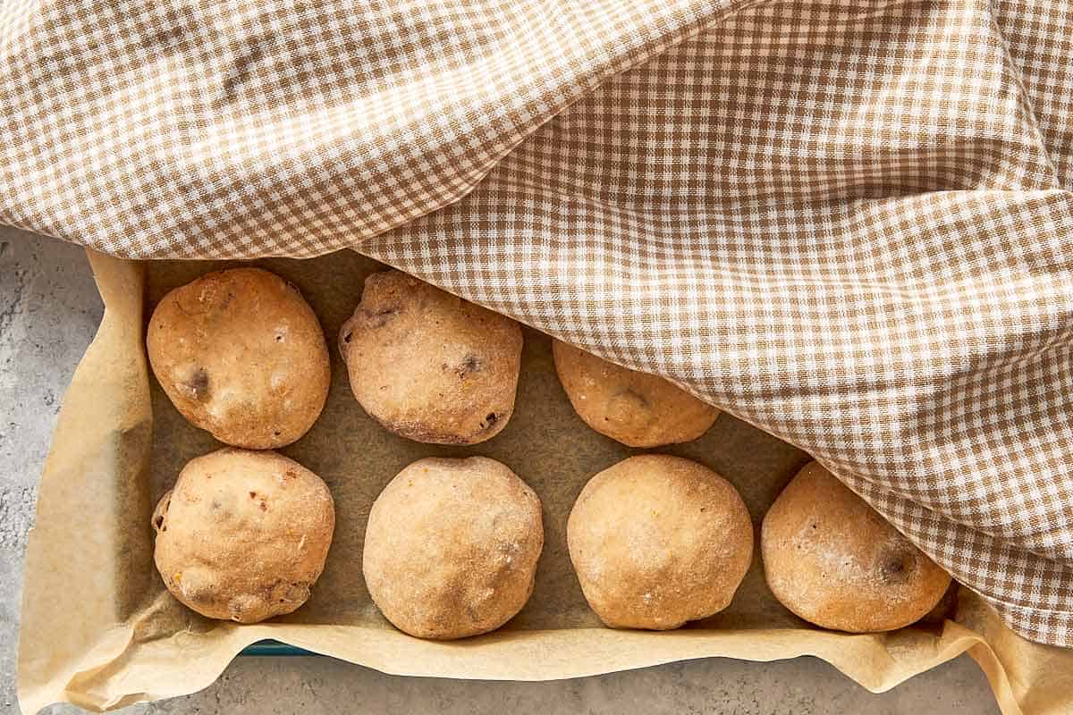 shaped dough balls rising in baking tray before baking