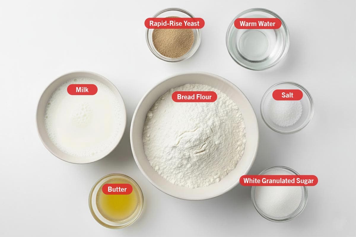 Top shot of ingredients: rapid-rise yeast, warm water, milk, bread flour, salt, butter, and white granulated sugar.