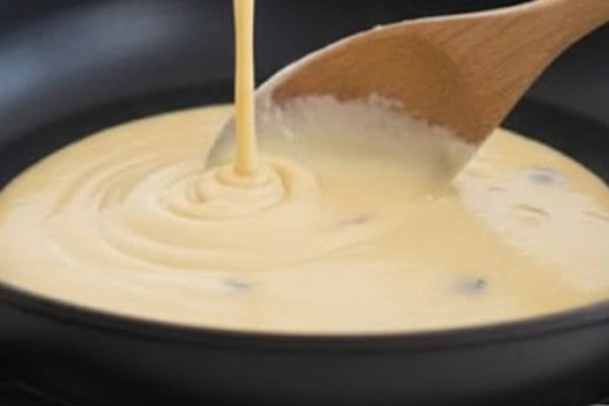 Using a 1/4 cup, pour batter onto the pan and spread with the back of the spoon to shape the pancakes.