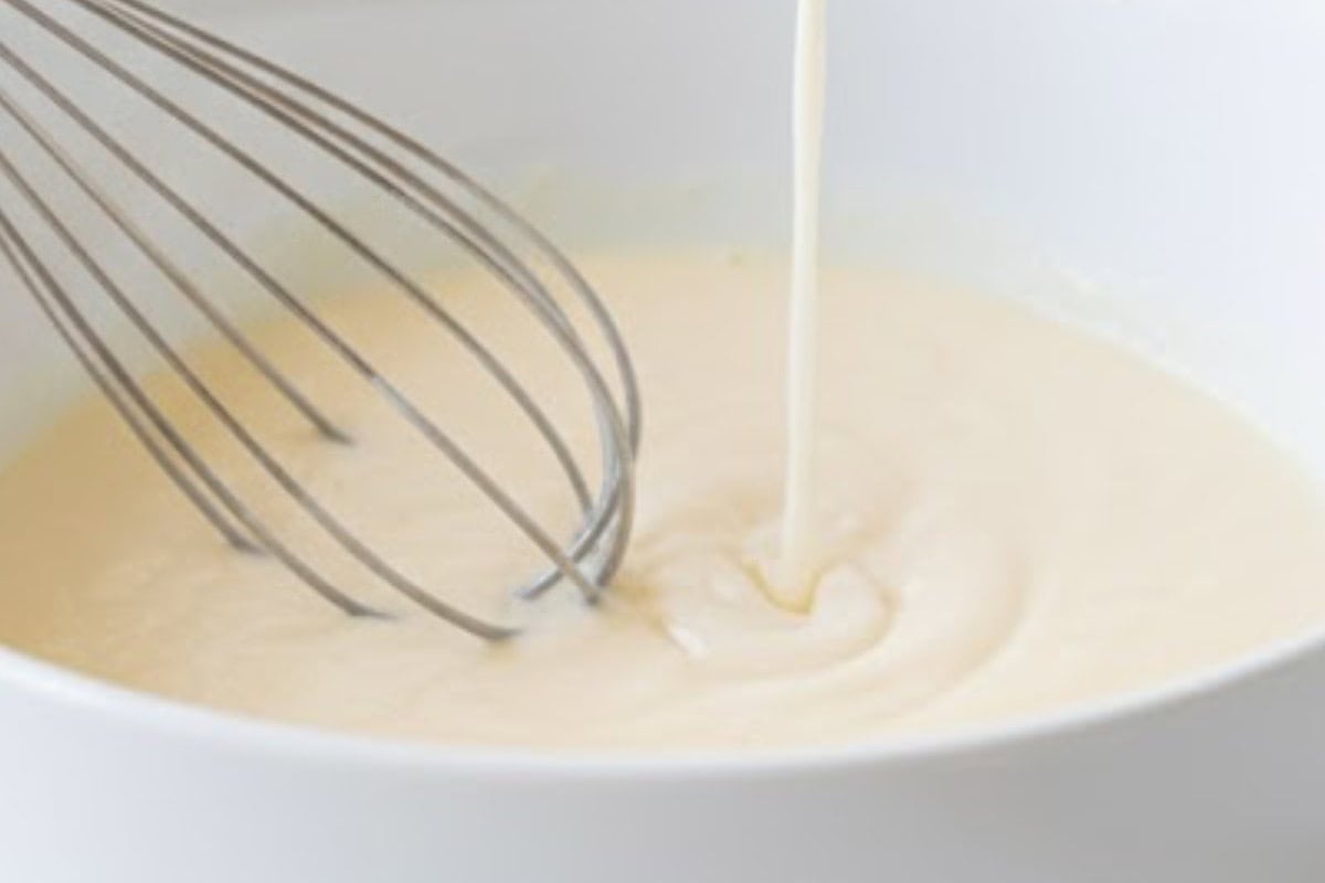 In a bowl, whisk eggs, coconut oil, vanilla, and yogurt until smooth. Add milk and mix