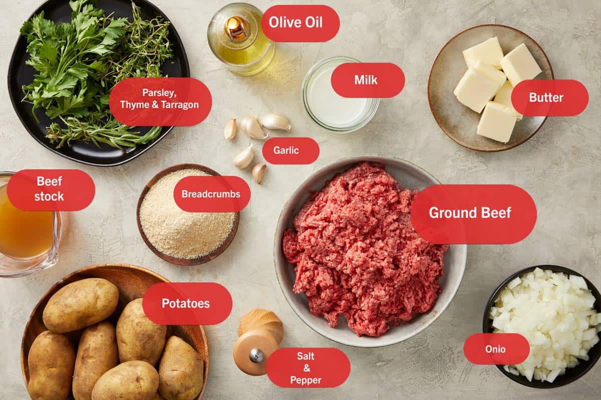 Ingredients for Shepherd's Pie arranged: potatoes, ground meat, onions, carrots, peas, stock, butter and milk.