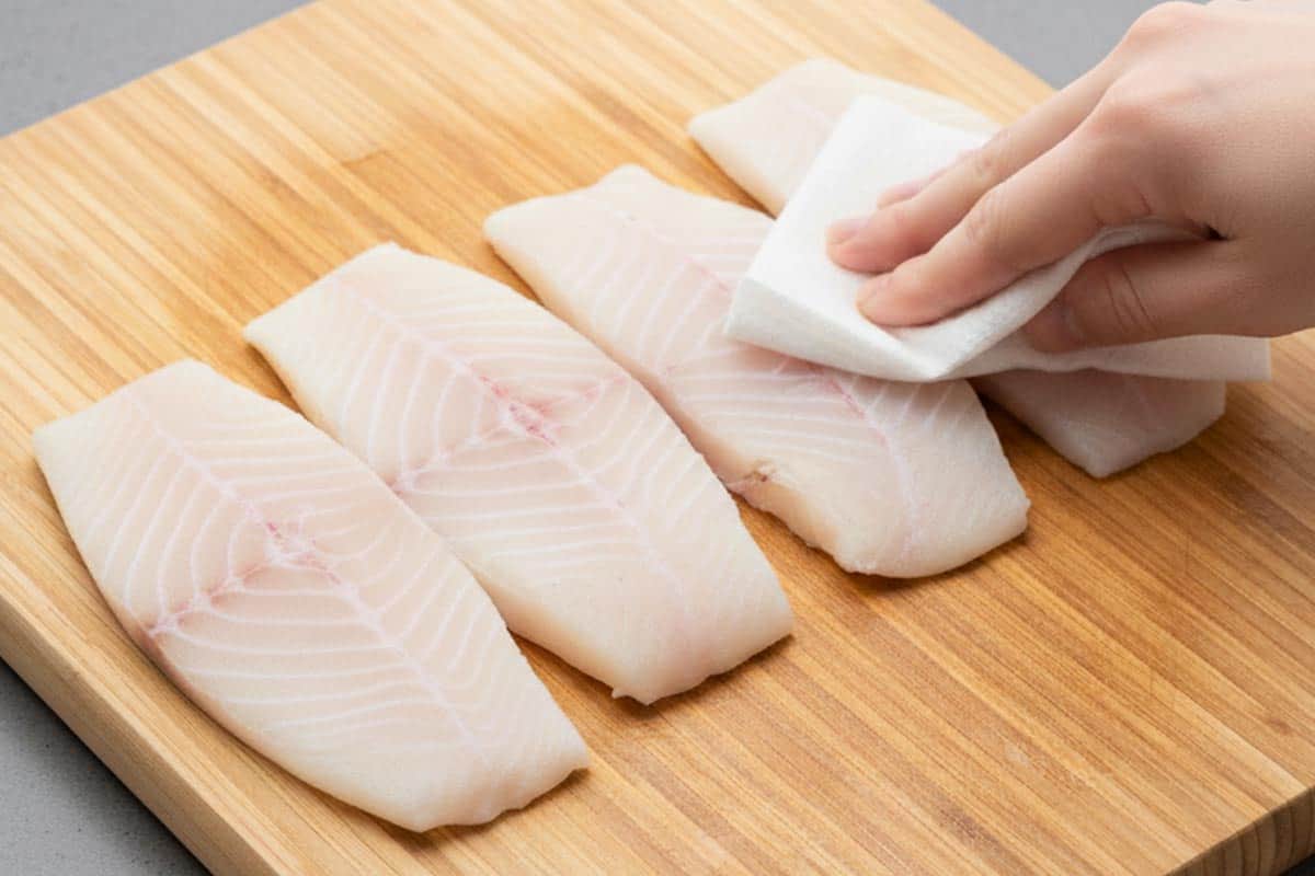 Patting fillets dry with paper towel.