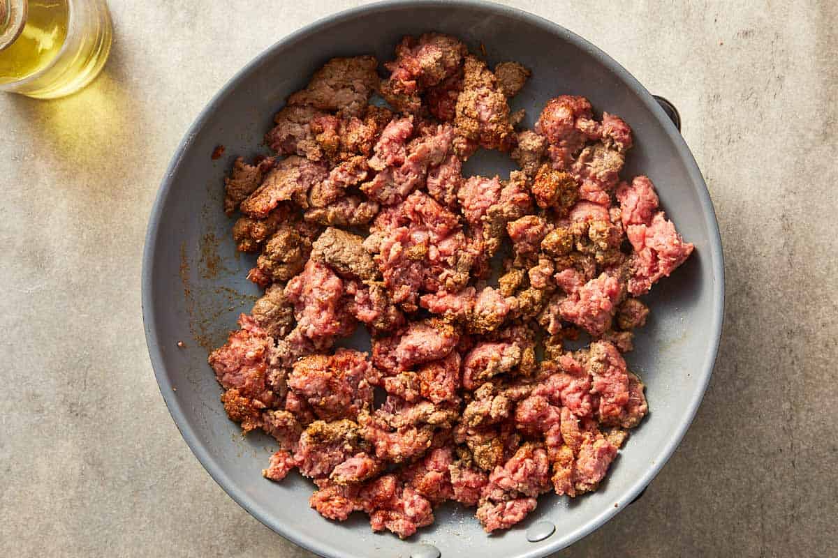 Top overview pf ground beef being cooked in a pan.