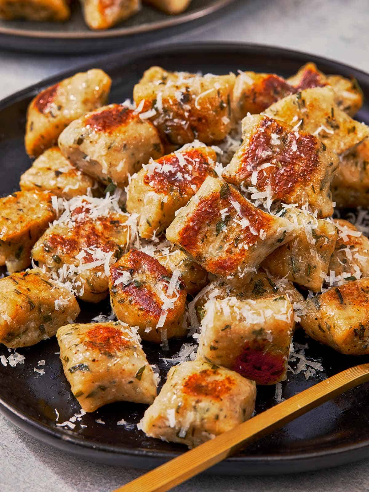 Crispy pan-fried gnocchi sprinkled with parmesan cheese.