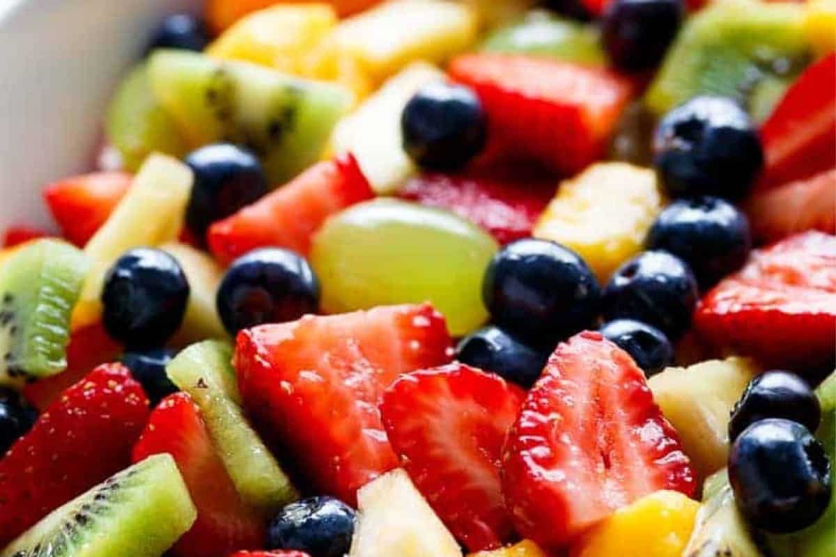 Place the washed and evenly sliced or diced strawberries, kiwi, mangoes, blueberries, grapes, and pineapple in a large salad bowl and combine everything.