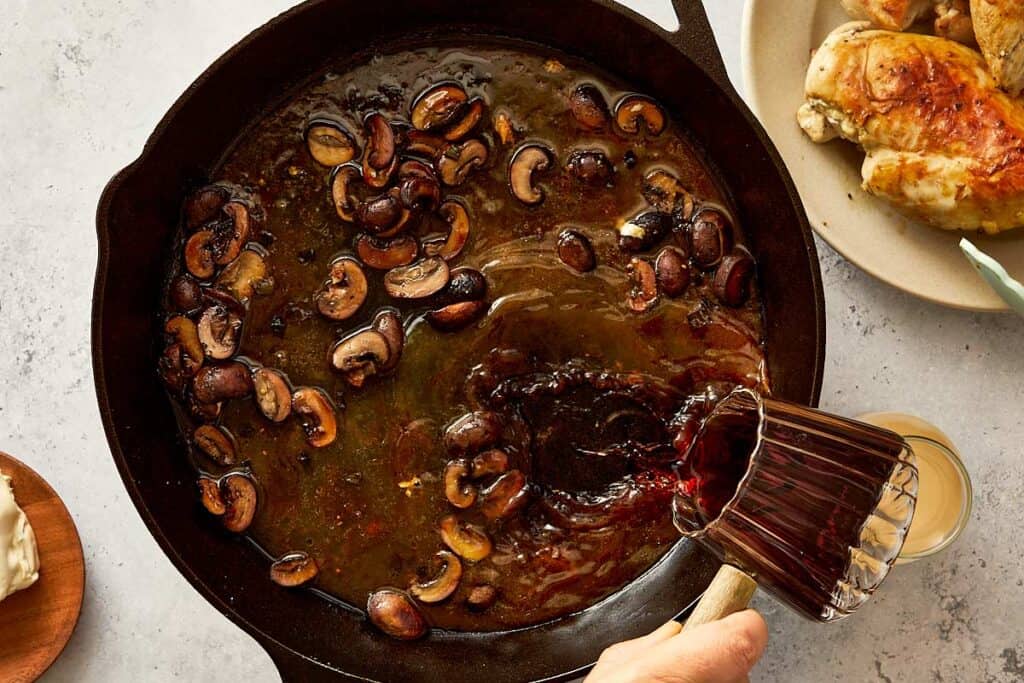a thick rich sauce of wine and mushrooms in a black skillet