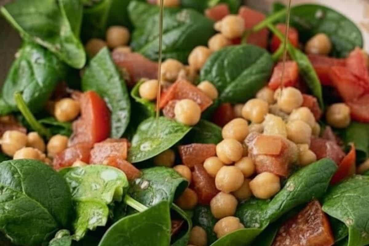 Add spinach, chickpeas, and tomatoes to a large bowl, then drizzle with garlic olive oil and lemon juice