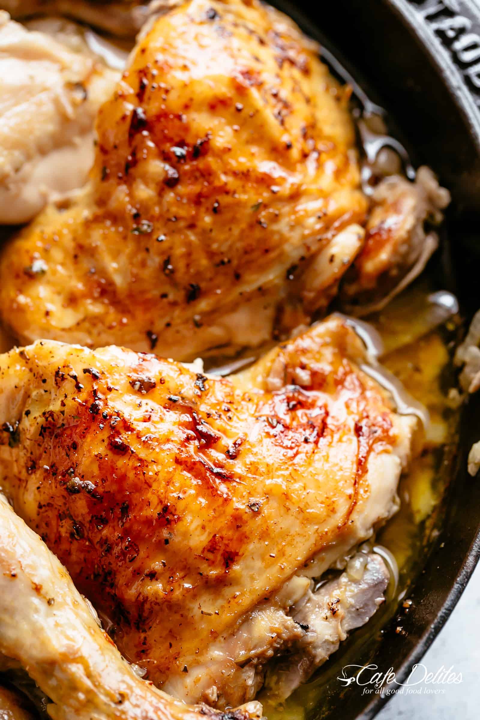 Close up image of roasted chicken piece in a skillet.