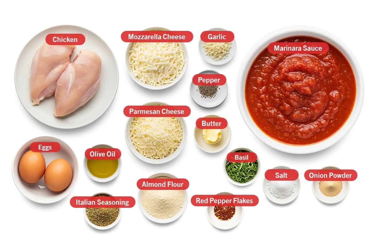 Top shot of ingredients: Chicken, mozzarella cheese, garlic, marinara sauce, pepper, parmesan cheese, butter, basil, salt, onion powder, eggs, olive oil, Italian seasoning, almond flour, and red pepper flakes.