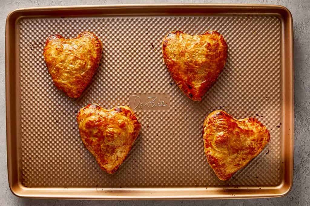a top down view of 4 heart shaped tarts baked on a tray