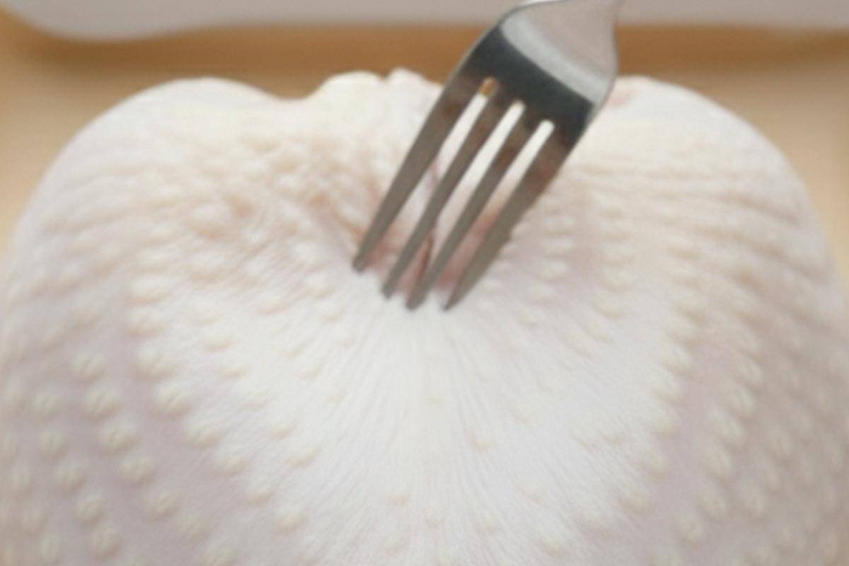 Piercing the skin and flesh of the turkey with a fork.
