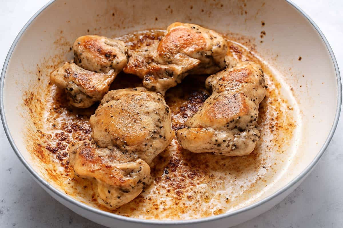 Seared chicken thighs in a cream pan