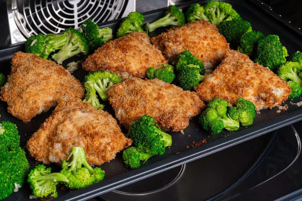 Broccoli and and oven fried chicken inside oven