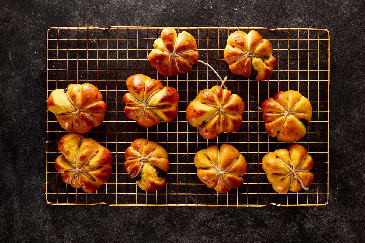 Freshly baked pumpkin breads cooling on a wire rack, golden and perfectly shaped.