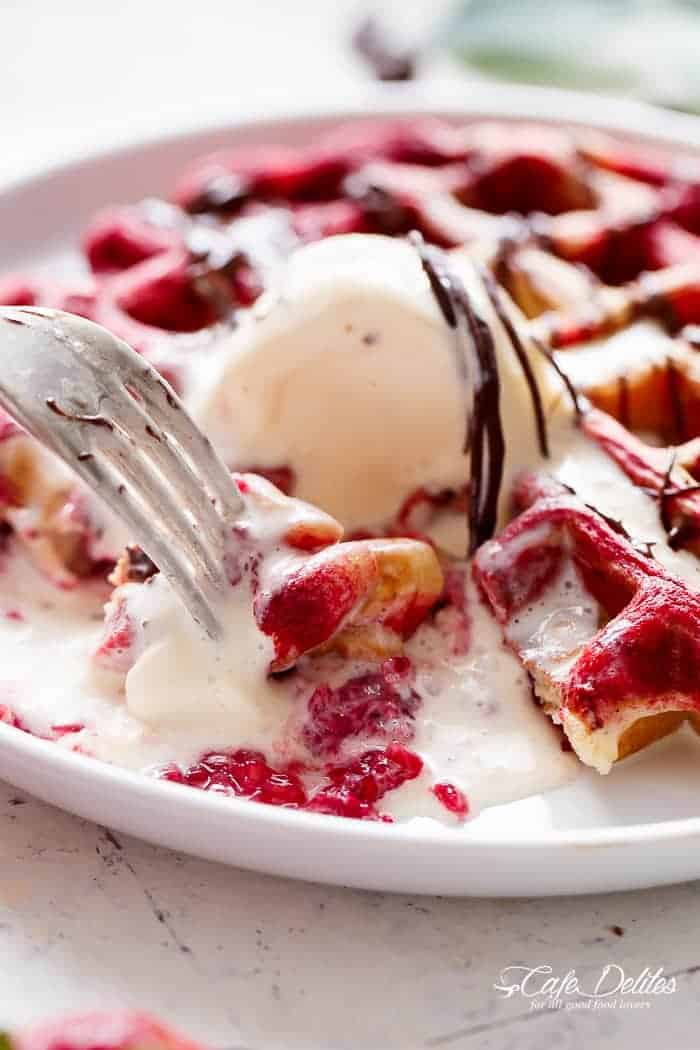 A piece taken from Red Velvet Marbled Waffles with ice cream scoop