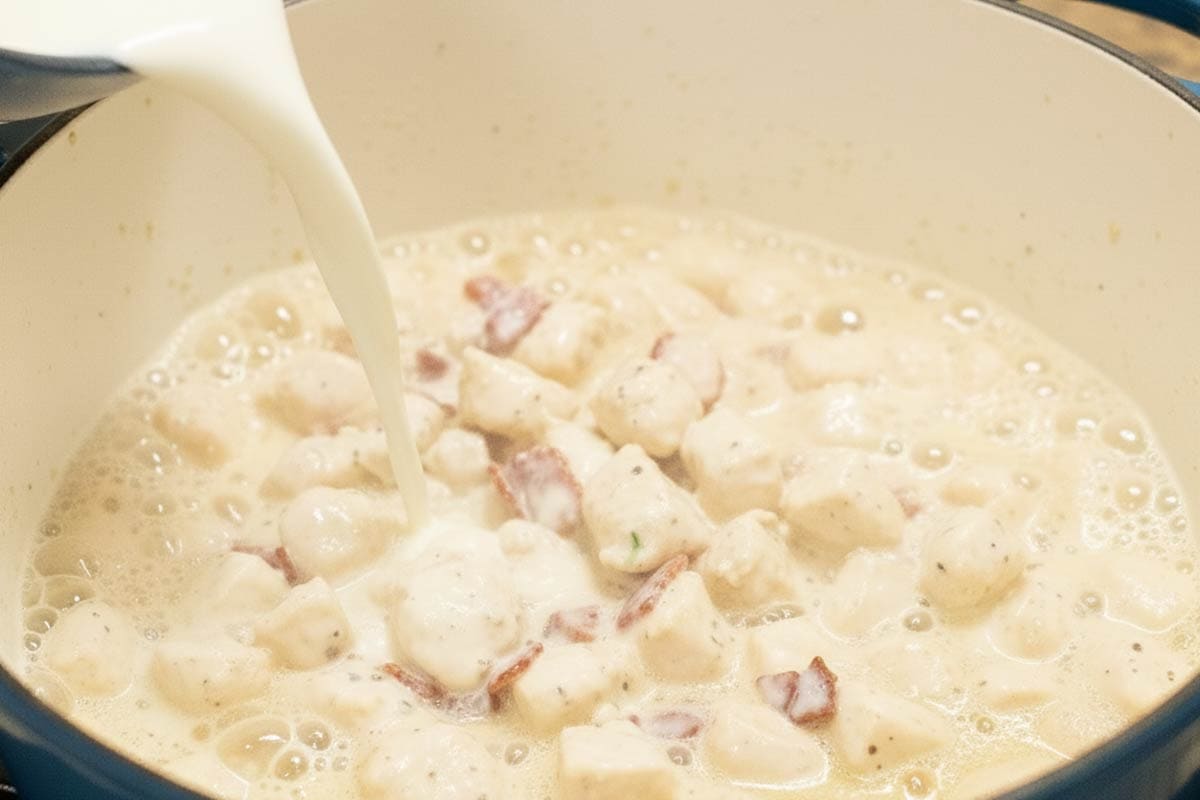Pouring in the milk to the pot.
