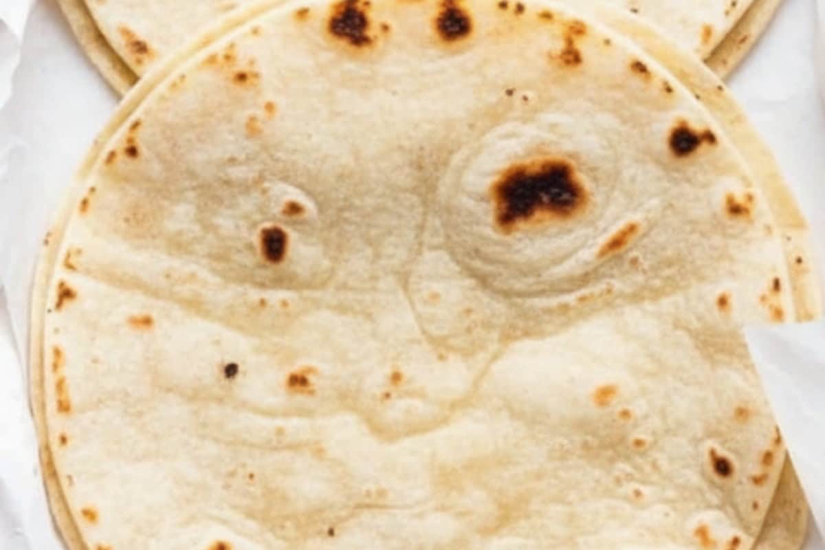 Heat the corn tortillas until soft and pliable, either in a dry skillet or wrapped in foil in the oven