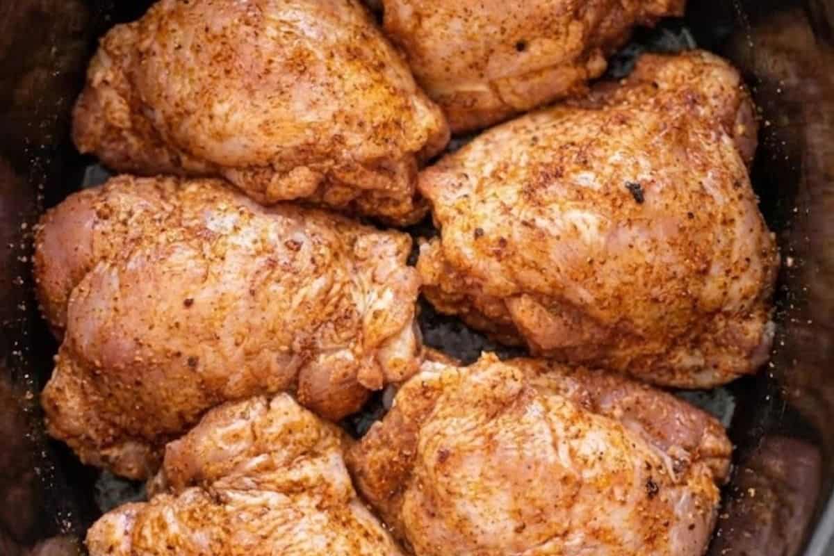 Transfer the seasoned chicken thighs in a 6 quart slow cooker bowl.