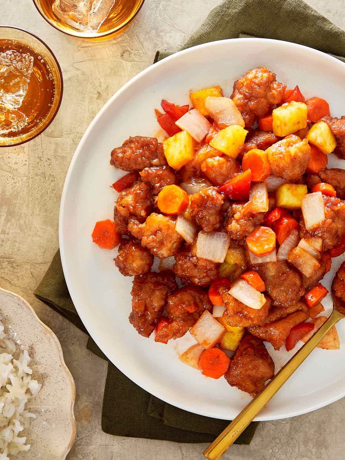 Plate of sweet and sour chicken with pineapple, carrots, red bell pepper, and onion.