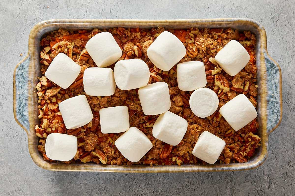 Overhead view of a sweet potato casserole with a layer of large, toasted marshmallows across the top.