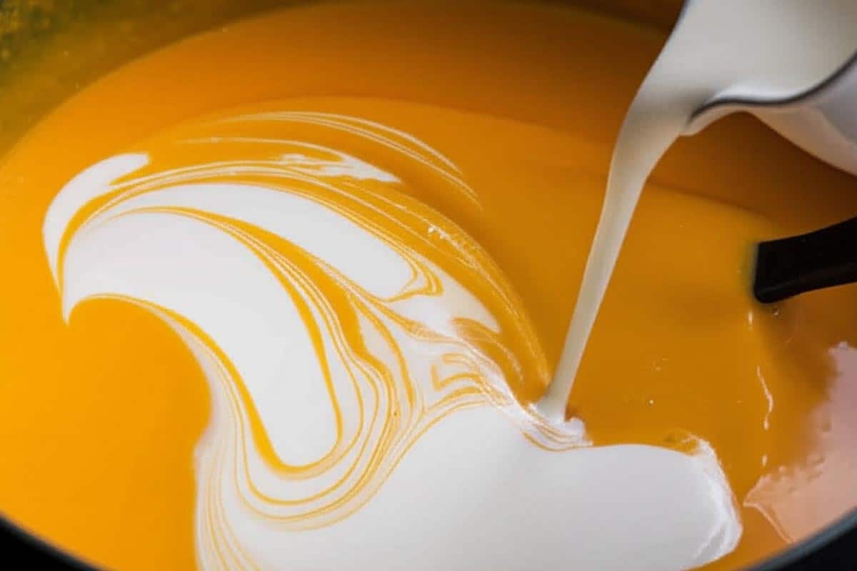 Adding cream to the soup.