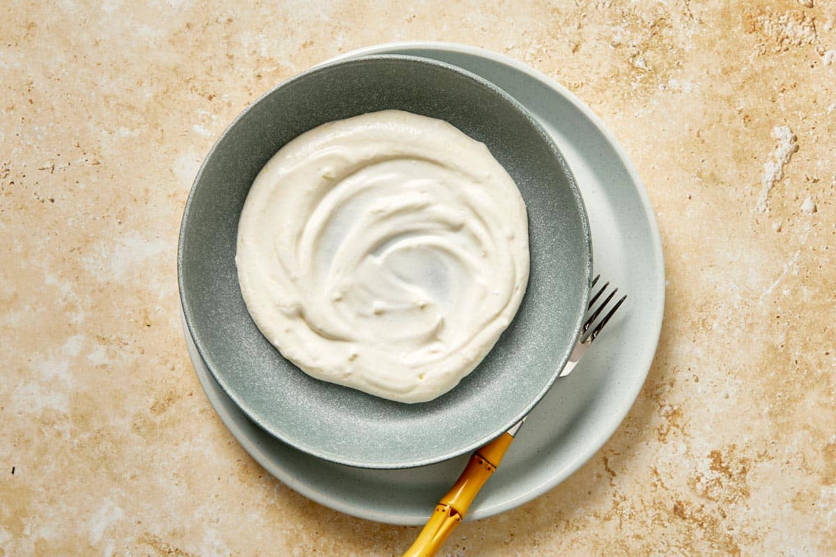 Creamy garlic yogurt spread in a shallow bowl.